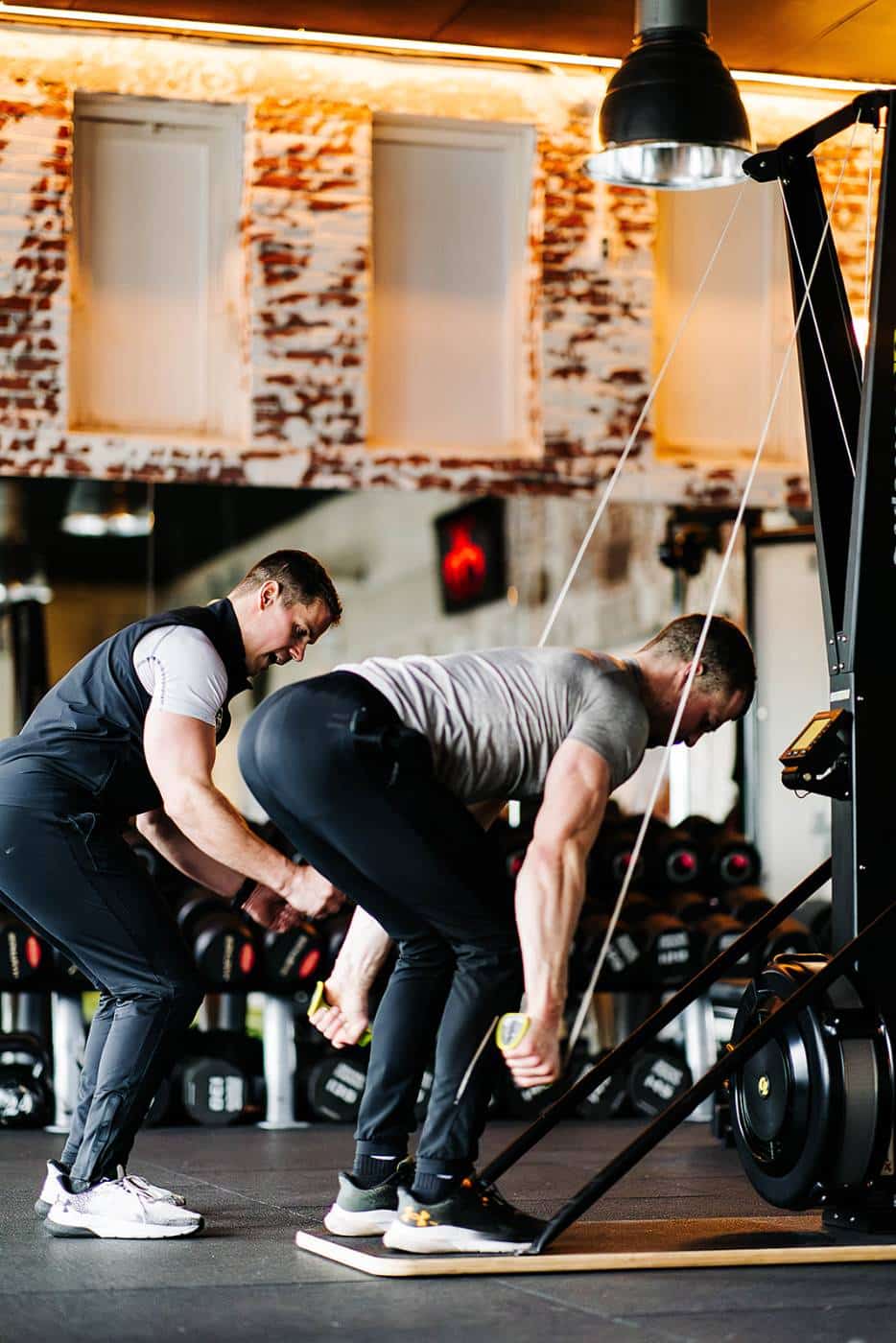 Personal trainer coacht een klant bij een deadlift