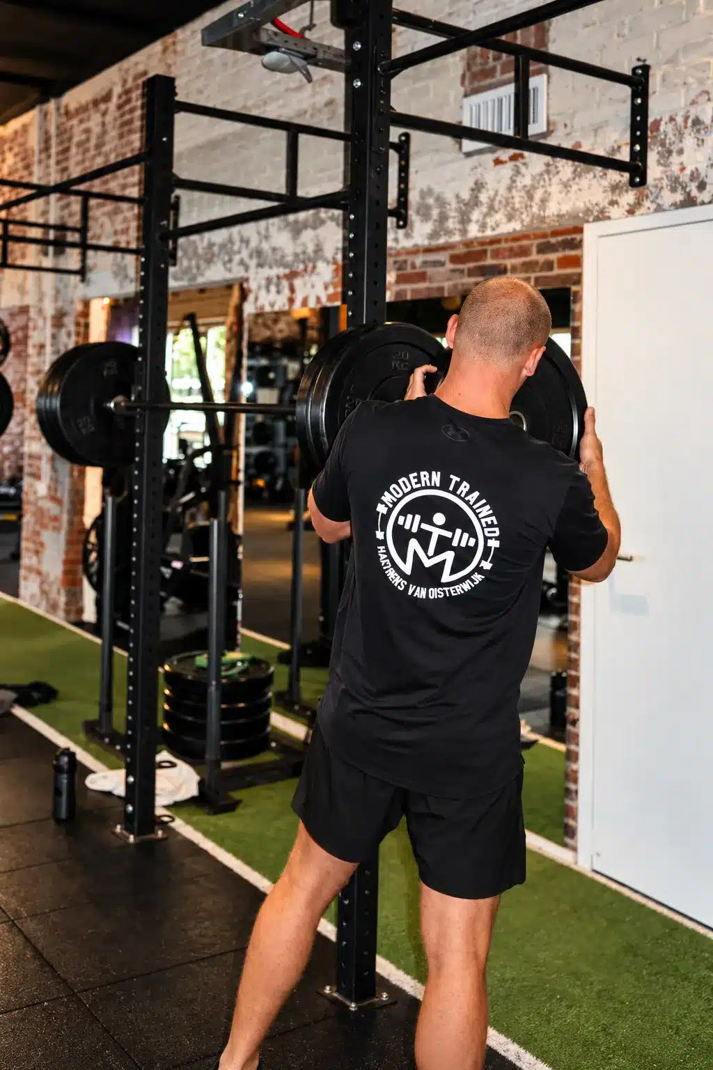 Trainer van Modern Trained met barbell in de gym