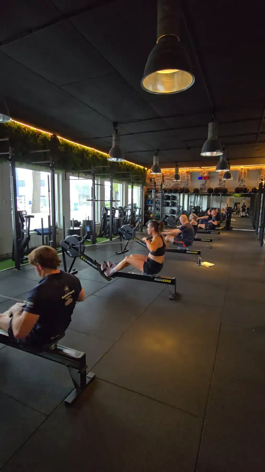 Deelnemers trainen op de roeiergometer en airbike bij Modern Trained